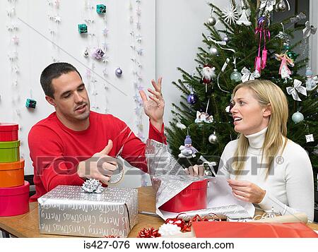 Couple wrapping christmas presents View Large Photo Image Stock Photograph - Couple wrapping christmas presents. Fotosearch