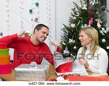 Couple wrapping christmas presents View Large Photo Image Stock Photography - Couple wrapping christmas presents. Fotosearch