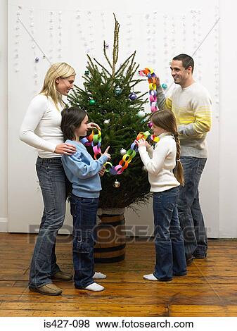 Stock Photo - Family decorating christmas tree. Fotosearch