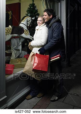 Mid adult couple christmas shopping View Large Photo Image Stock Image - Mid adult couple christmas shopping. Fotosearch
