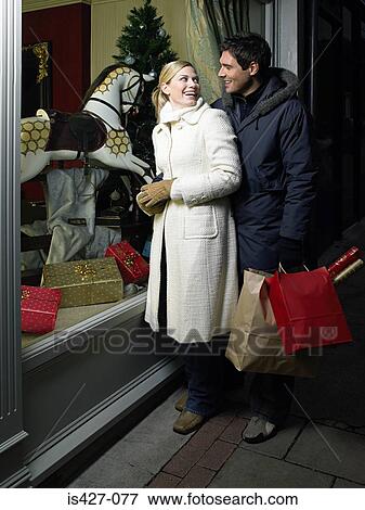Stock Photo - Mid adult couple christmas shopping. Fotosearch