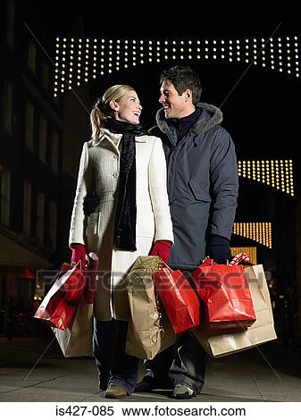 Stock Photography - Mid adult couple christmas shopping. Fotosearch