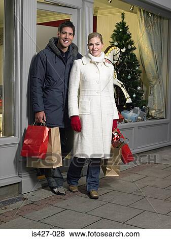 Mid adult couple walking out shop View Large Photo Image Stock Photo - Mid adult couple walking out shop. Fotosearch