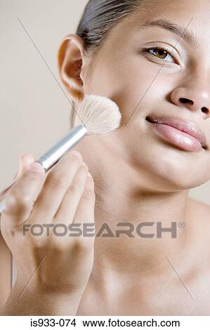Picture - Girl applying face powder. Fotosearch