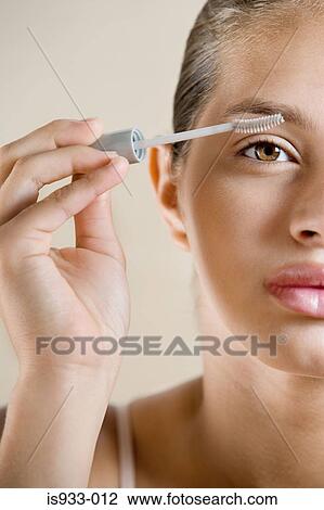 Stock Image - Girl applying mascara. Fotosearch