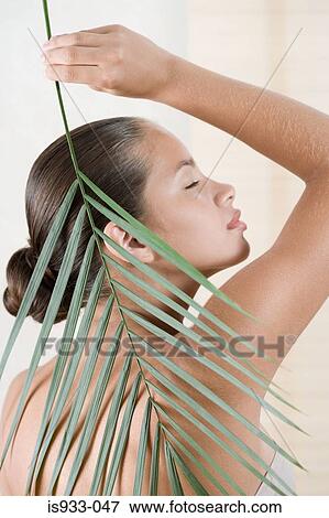 Girl holding a palm leaf View Large Photo Image Stock Photo - Girl holding a palm leaf. Fotosearch