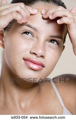 Girl touching her forehead View Large Photo Image Picture - Girl touching her forehead. Fotosearch