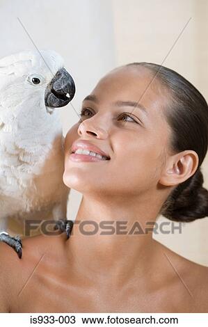 Stock Image - Girl with cockatoo on her shoulder. Fotosearch