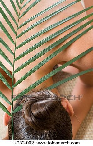 Girl with palm leaf on her back View Large Photo Image Stock Image - Girl with palm leaf on her back. Fotosearch