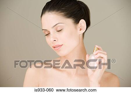 Young woman spraying perfume View Large Photo Image Stock Image - Young woman spraying perfume. Fotosearch