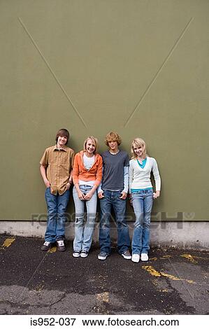 Stock Photo - Four teenagers leaning against a wall. Fotosearch