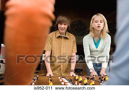 Four teenagers playing table football View Large Photo Image Stock Image - Four teenagers playing table football. Fotosearch