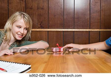 Teenage boy giving girl a present View Large Photo Image Stock Photograph - Teenage boy giving girl a present. Fotosearch