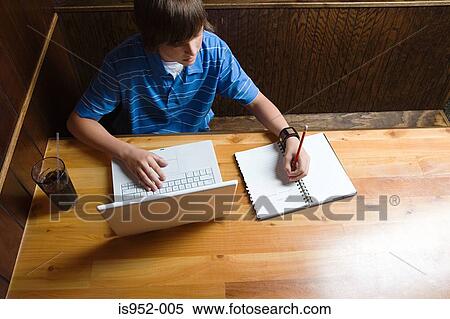 Teenage boy in cafe doing homework View Large Photo Image Stock Photography - Teenage boy in cafe doing homework. Fotosearch