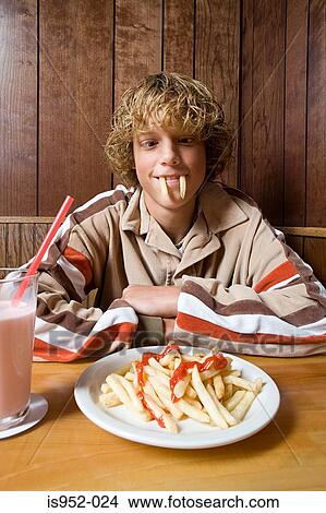 Teenage boy playing with his food View Large Photo Image Picture - Teenage boy playing with his food. Fotosearch