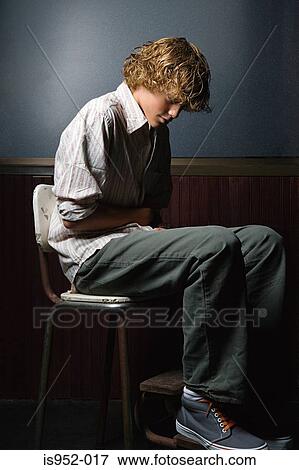 Stock Photo - Teenage boy sat alone. Fotosearch