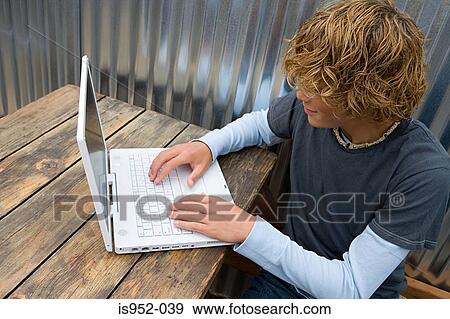 Teenage boy working on a laptop computer View Large Photo Image Stock Photo - Teenage boy working on a laptop computer. Fotosearch