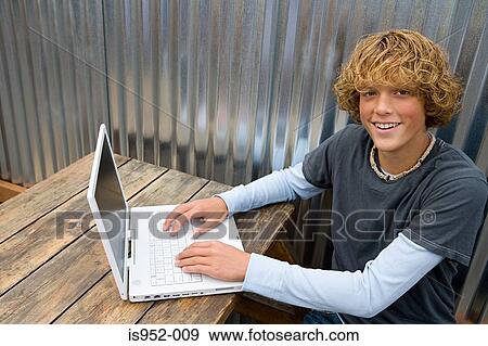 Teenage boy working on laptop View Large Photo Image Stock Photo - Teenage boy working on laptop. Fotosearch