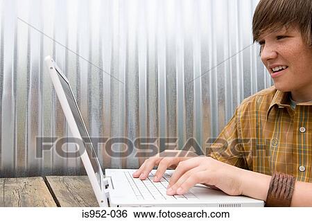 Stock Photograph - Teenage boy working on laptop. Fotosearch