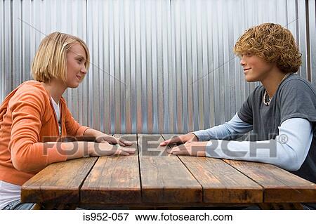 Stock Photo - Teenage couple sat facing each other. Fotosearch