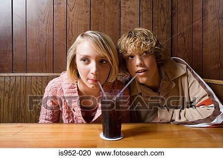 Teenage couple sharing a soft drink View Large Photo Image Stock Image - Teenage couple sharing a soft drink. Fotosearch