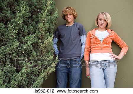 Stock Image - Teenage couple stood outdoors. Fotosearch