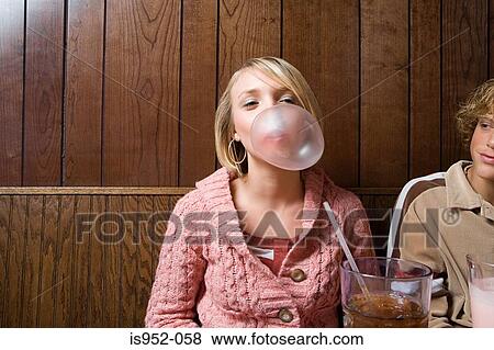 Teenage girl blowing a bubble View Large Photo Image Stock Photo - Teenage girl blowing a bubble. Fotosearch