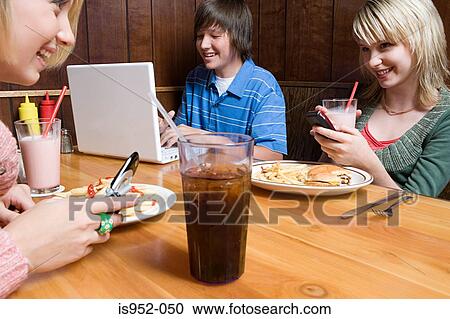 Stock Image - Three teenagers at a cafe. Fotosearch