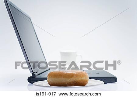 Stock Photo - Coffee and doughnut by a laptop. Fotosearch