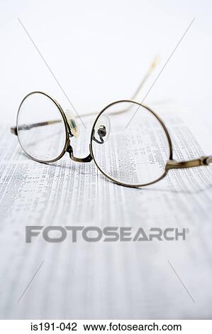 Stock Image - Glasses on financial pages. Fotosearch