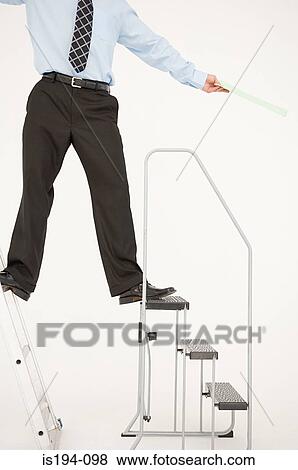 Businessman balancing on two ladders View Large Photo Image Stock Photo - Businessman balancing on two ladders. Fotosearch