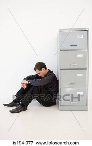 Businessman hiding behind filing cabinet View Large Photo Image Stock Photo - Businessman hiding behind filing cabinet. Fotosearch