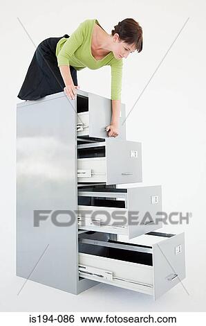 Businesswoman on top of filing cabinet View Large Photo Image Stock Photograph - Businesswoman on top of filing cabinet. Fotosearch