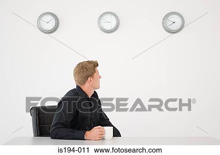 Stock Image - Portrait of a businessman checking time. Fotosearch