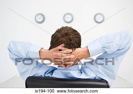 Relaxed businessman watching clocks View Large Photo Image Stock Image - Relaxed businessman watching clocks. Fotosearch