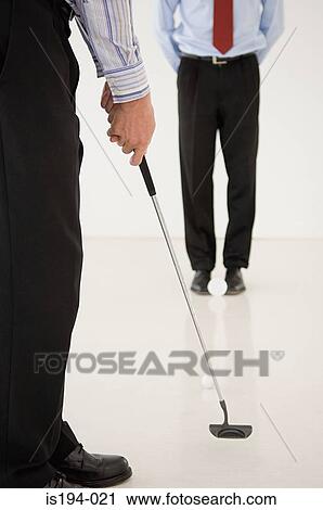 Two businessmen practicing golf View Large Photo Image Stock Image - Two businessmen practicing golf. Fotosearch