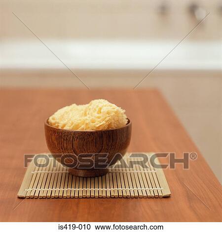 Stock Image - Sponge in a wooden bowl. Fotosearch
