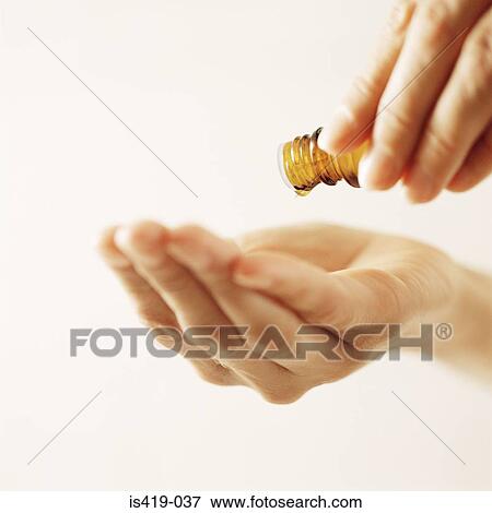 Stock Photo - Woman pouring essential oil. Fotosearch