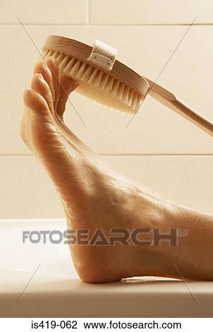 Woman scrubbing her toes View Large Photo Image Stock Image - Woman scrubbing her toes. Fotosearch