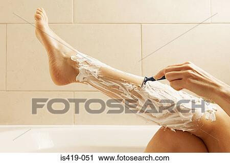 Stock Image - Woman shaving her legs. Fotosearch