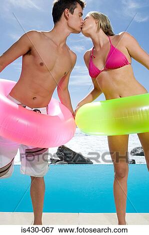 Stock Photo - Couple kissing by the pool. Fotosearch