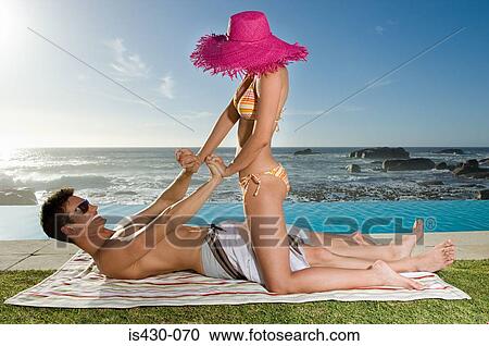 Couple playfighting by the pool View Large Photo Image Stock Image - Couple playfighting by the pool. Fotosearch