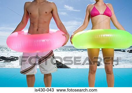 Couple with inflatable rings View Large Photo Image Stock Image - Couple with inflatable rings. Fotosearch