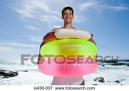 Man holding inflatable and rubber rings View Large Photo Image Stock Photo - Man holding inflatable and rubber rings. Fotosearch