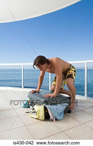 Man trying to close suitcase View Large Photo Image Stock Image - Man trying to close suitcase. Fotosearch