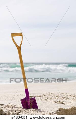 Stock Image - Spade in the sand. Fotosearch