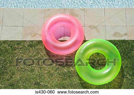 Two inflatable rings by the pool View Large Photo Image Stock Image - Two inflatable rings by the pool. Fotosearch
