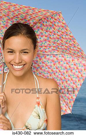 Woman in bikini holding umbrella View Large Photo Image Stock Image - Woman in bikini holding umbrella. Fotosearch