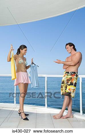 Stock Photo - Woman showing clothing to boyfriend. Fotosearch