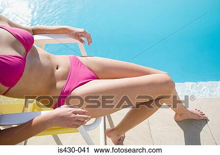 Stock Image - Woman sitting by the pool. Fotosearch
